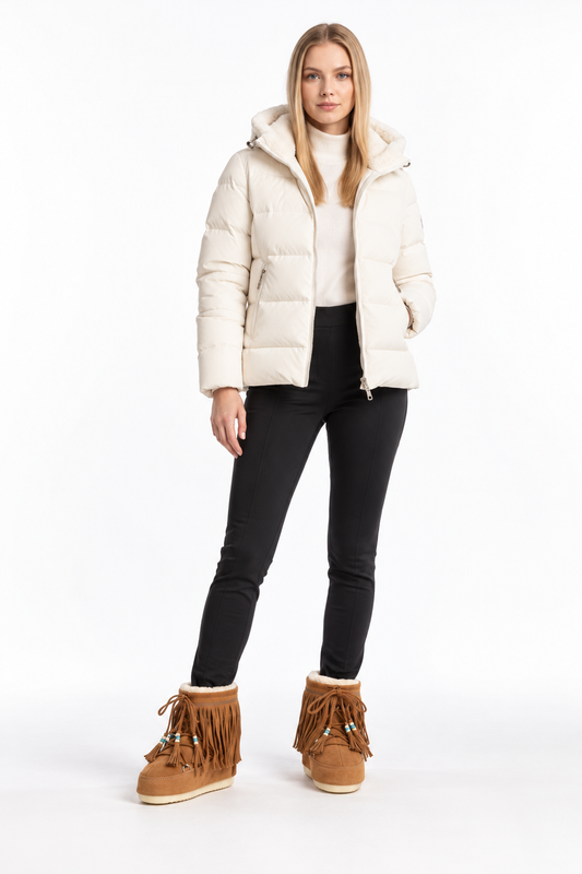 Woman in an ivory ski jacket and black skinny trousers wearing Alanui x Moon Boot fringed suede boots