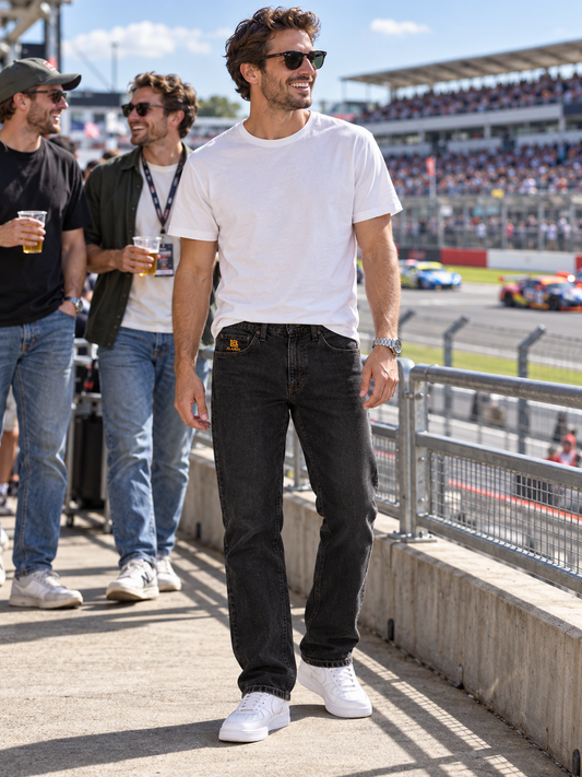 XLARGE black stitched denim jeans W30, front view on a man at a motor racing day